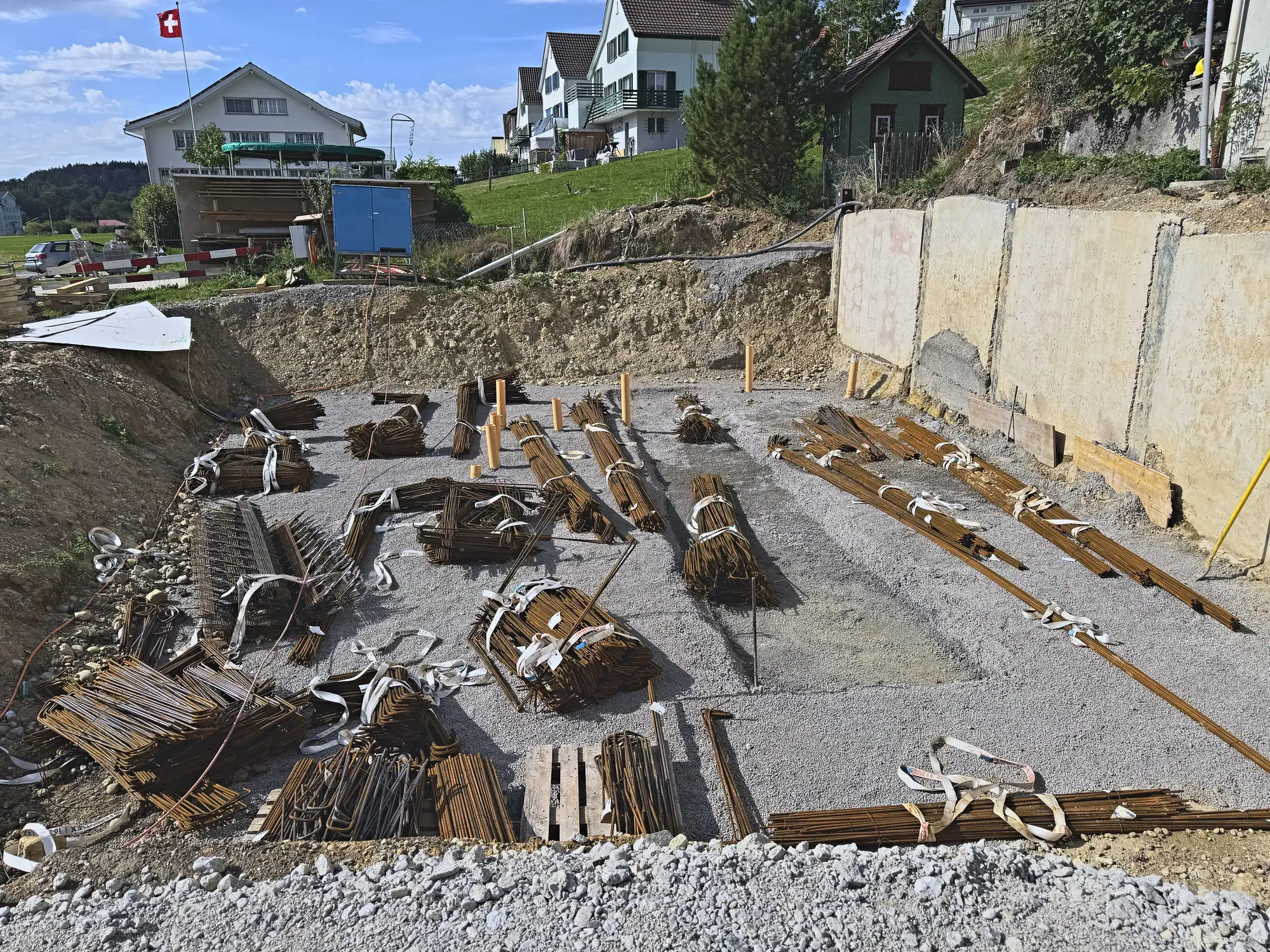 Baugrubensohle mit sortierten Bewehrungsbündeln, Stützmauer an der Hangseite