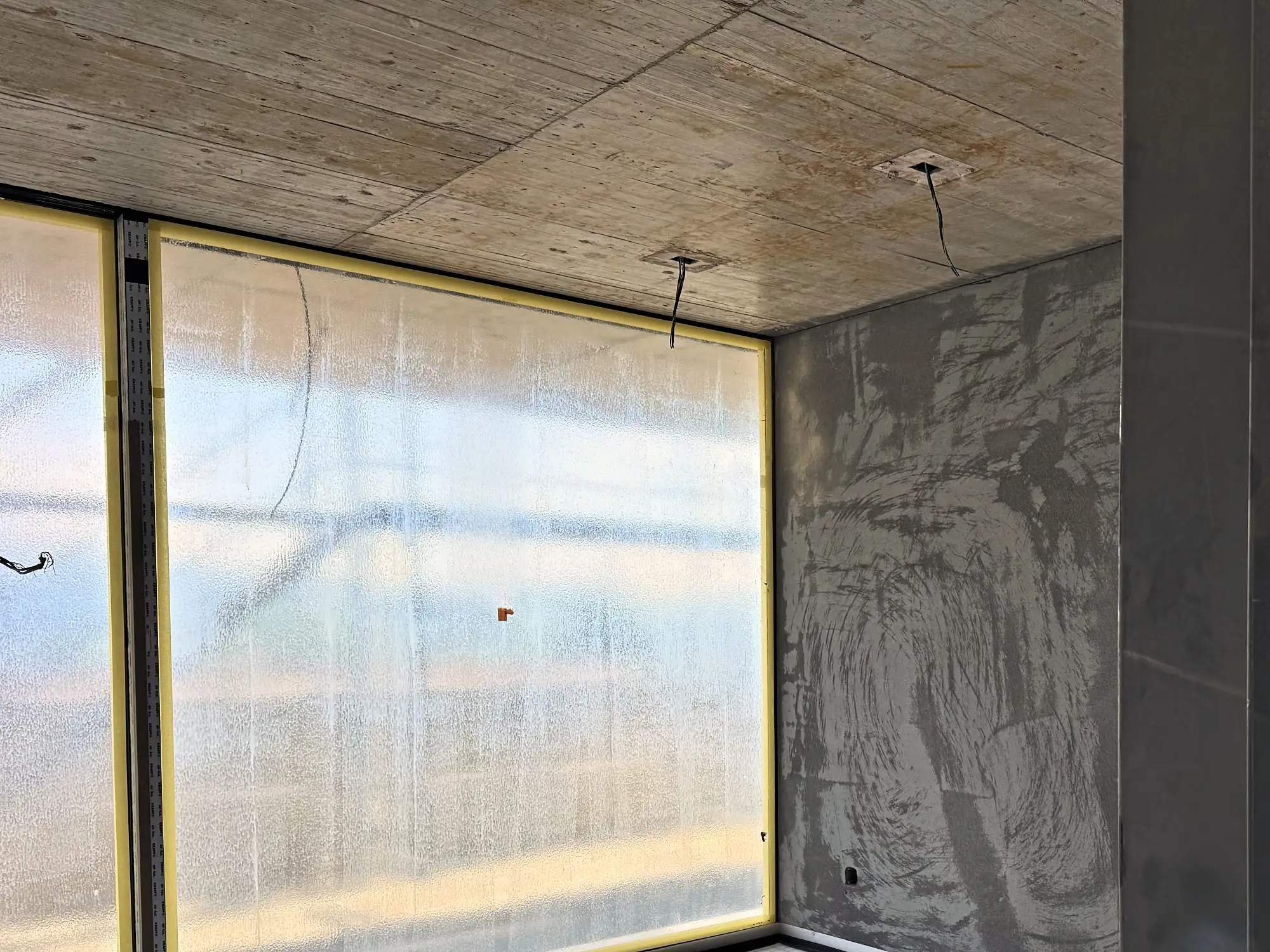 Innenraum mit Fensterfront und Sichtbetondecke