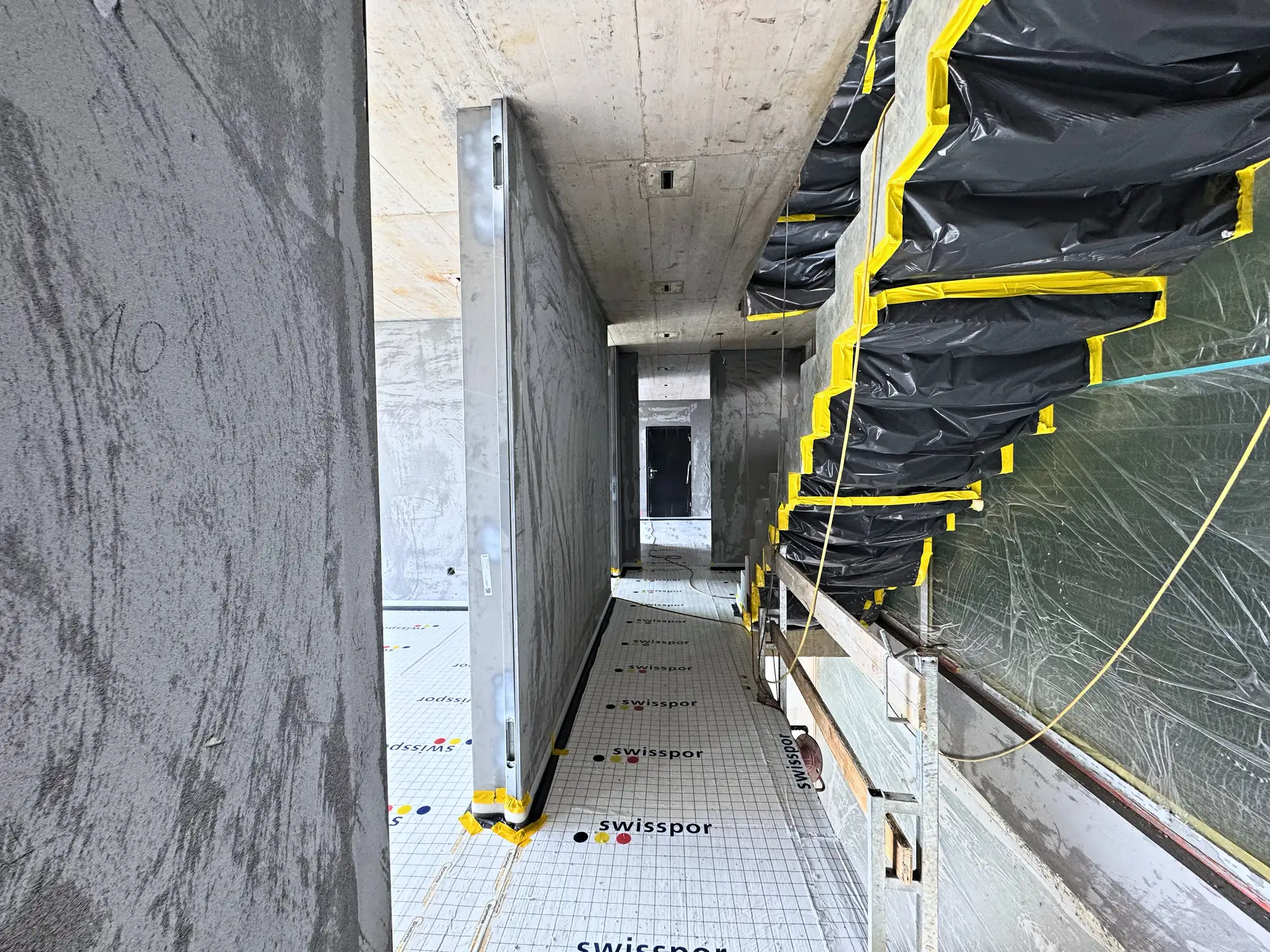 Laubengang im Rohbau, Bodendämmung ausgelegt, Fassade abgedeckt